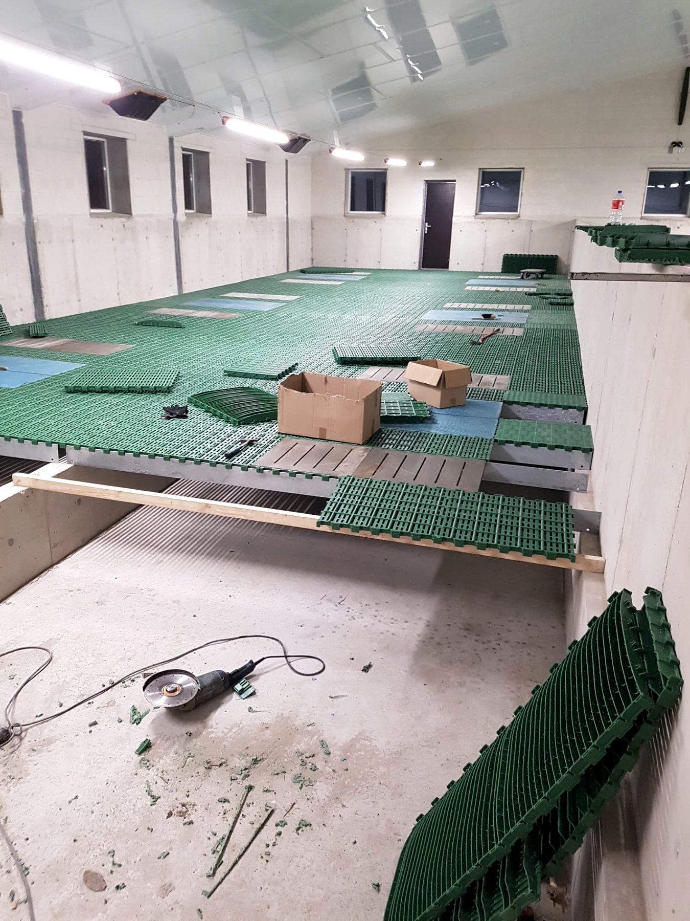 Montage von Kunststoffrosten in einem fertigen Stallinnenraum