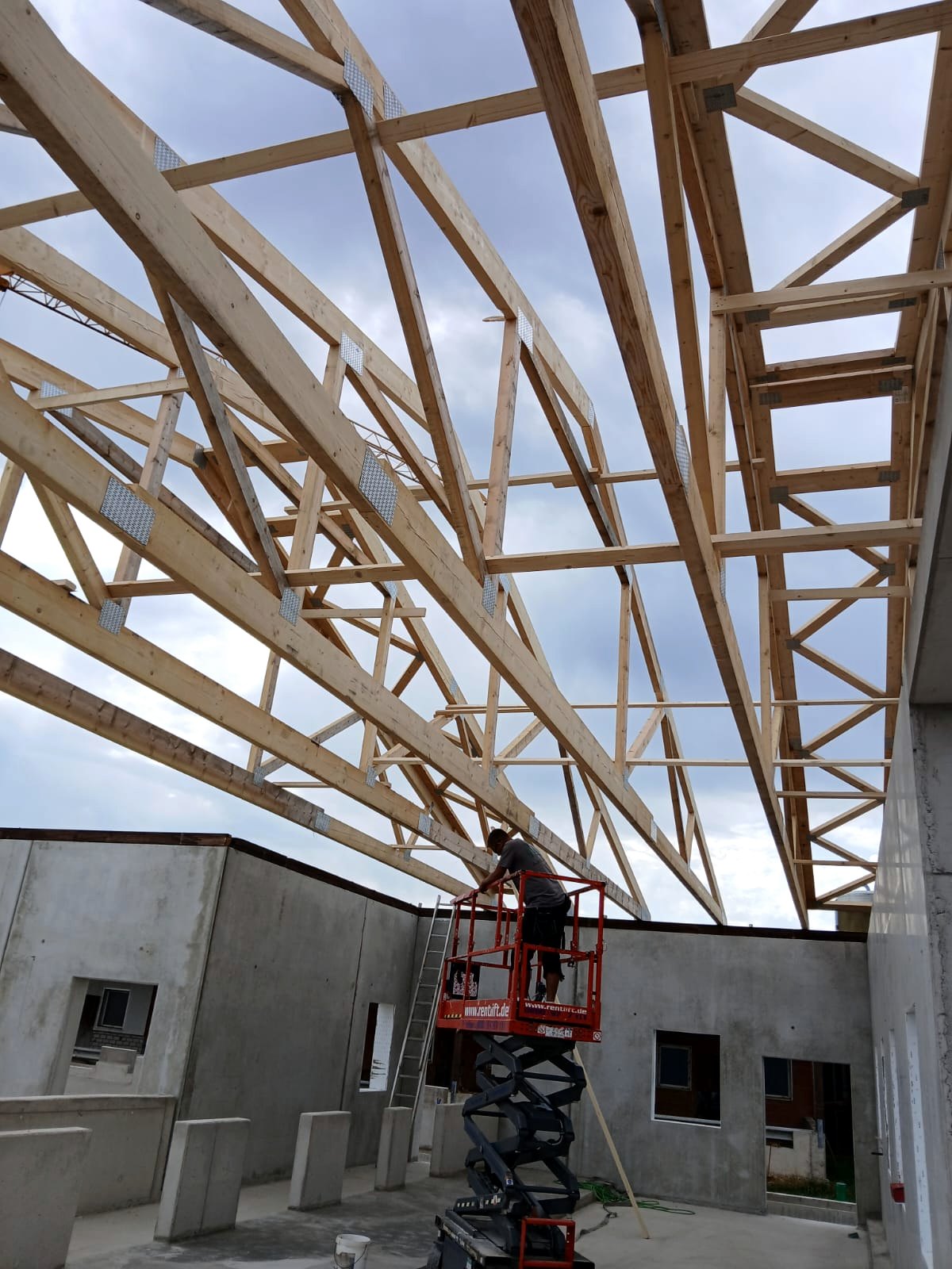 Montage eines Dachstuhls aus Holzbindern über einem Stallneubau